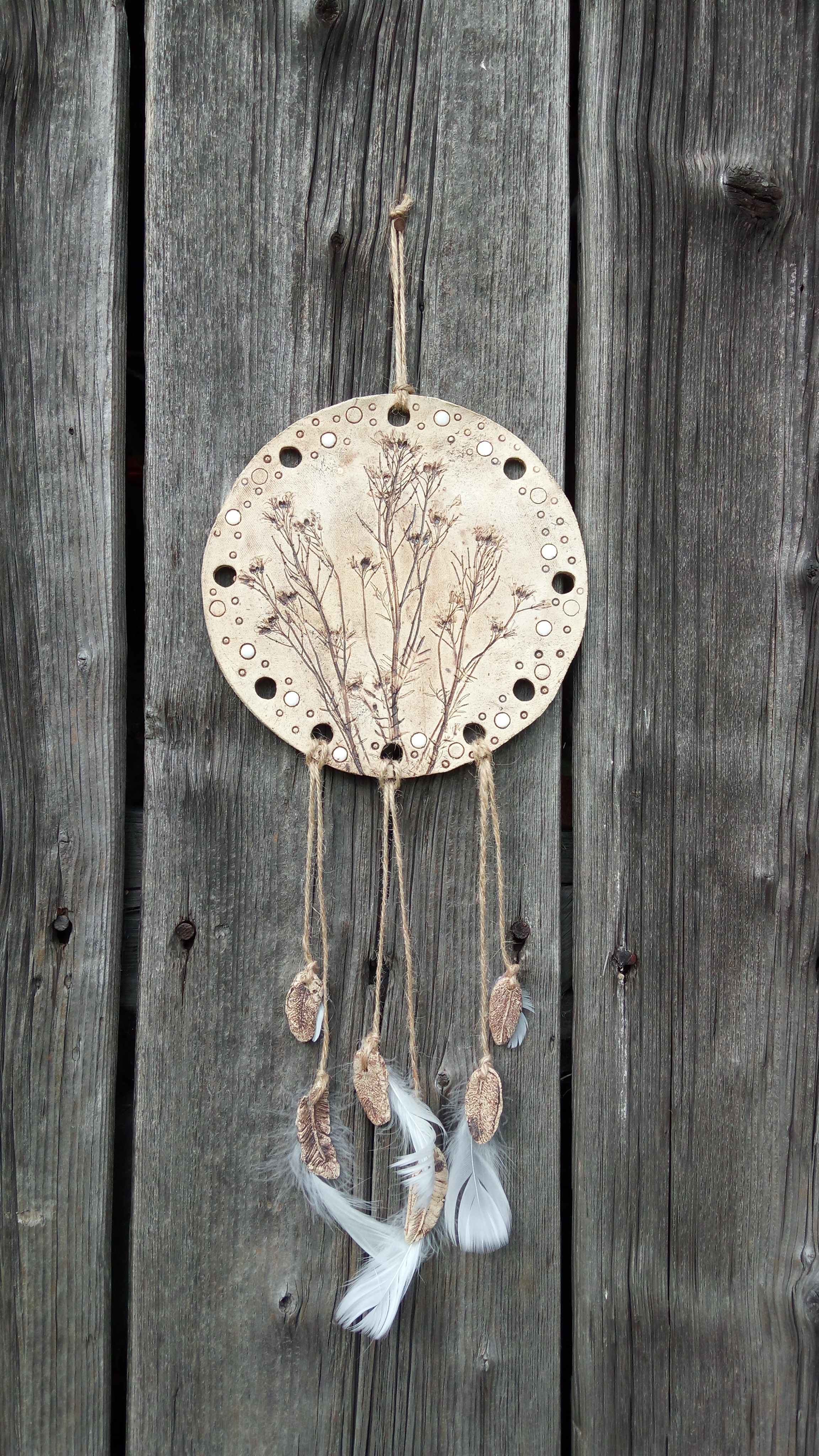 Keramický lapač snů v trávě